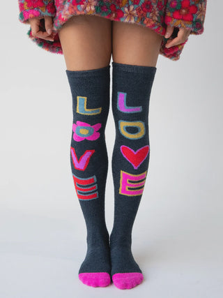 Person wearing knee-high socks with colorful 'LOVE' design