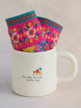 Floral-patterned socks on a white mug