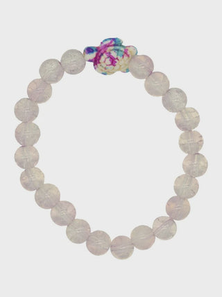 Bracelet with white beads and a colorful charm on a white background