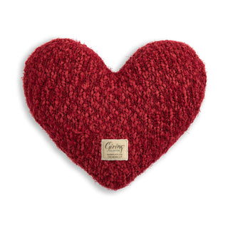 Red heart-shaped pillow with a label 
