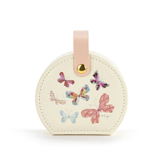 Round cream-colored travel jewelry case with colorful butterfly designs and a pink strap 
