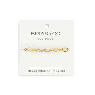 Gold bracelet on a Briar & Co. card with product details.