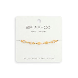 Gold bracelet on a Briar & Co. card with a white background