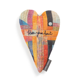 Heart-shaped patchwork pillow with colorful pattern and 'Bless your heart' text on a white background