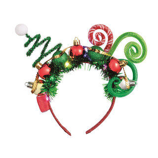 A whimsical Christmas headband featuring large red-and-white candy cane elements, curled green and red mesh extensions, green glittery gift boxes, round ornaments, peppermint candy accents, and a red tulle base.