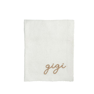 White throw blanket with 'gigi' embroidery on a white background