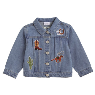 A child's blue denim jacket decorated with Western-themed patches, including a cowboy boot, cactus, horseshoe, and a rider on horseback.