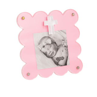 Pink photo frame with scalloped edges holding a black and white photo of a baby.