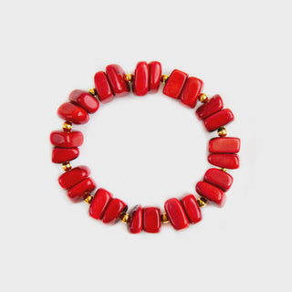 Red beaded bracelet with gold accents on a light gray background
