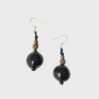 Pair of black beaded earrings on a light gray background