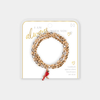 A three-strand stretch bracelet set in rose gold with clear rhinestones and a small red cardinal charm, displayed on a white card with gold lettering.