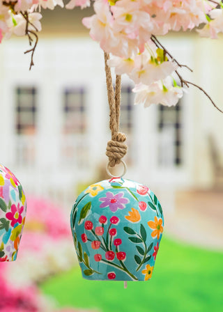 Metal Decorative bell with floral pattern hanging from a tree