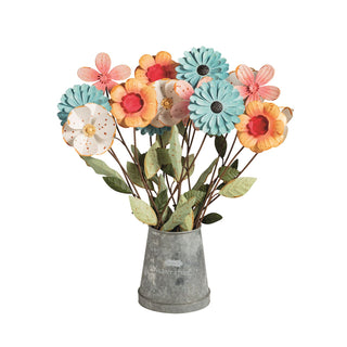 Bouquet of colorful artificial flowers in a gray vase on a white background