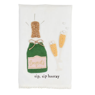 Decorative towel with embroidered bottle and champagne flute on a white background