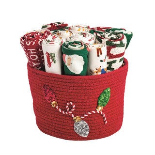 Red basket filled with Christmas-themed fabric rolls 