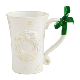 White ceramic mug with decorative wreath design and a green ribbon on a white background