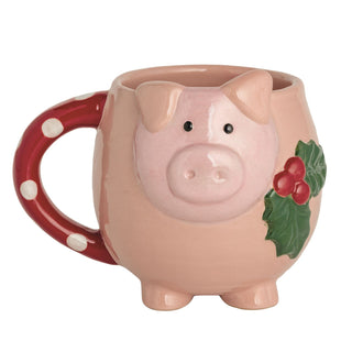 Pig-shaped mug with a red handle and holly design on a white background