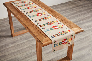 Wooden bench with a decorative table runner featuring gingerbread men 