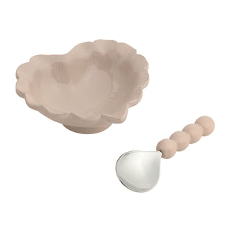 Beige ceramic bowl with a silver spoon on a white background