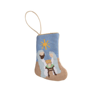 Decorative nativity scene ornament with a blue background and straw roof, featuring Mary, Joseph, and baby Jesus.