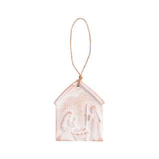 Decorative nativity ornament with a string on a white lace background