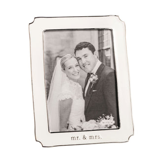 Silver photo frame with 'Mr. & Mrs.' engraving, containing a wedding photo of a couple.