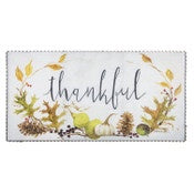 Decorative mat with 'thankful' text and autumn leaves on a white background