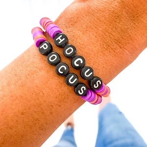 Bracelet Set with word beads spelling Hocus Focus on a wrist against a white background