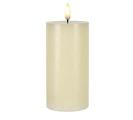 Beige candle with a lit wick on a white background