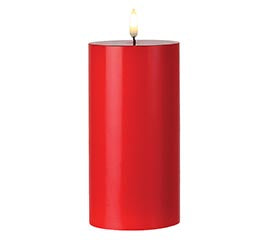 Red candle with a visible flame on a white background
