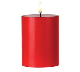 Red candle with a lit wick on a white background