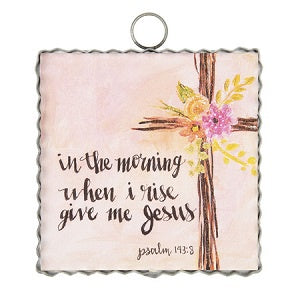 Decorative plaque with cross and flowers on a light background and the text 'in the morning when i rise give me jesus'
