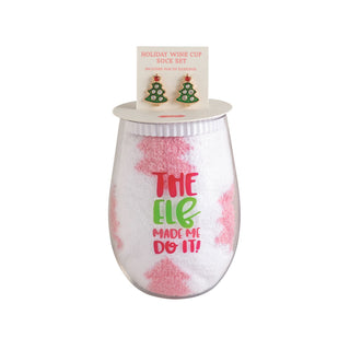 'The Elf Made Me Do It' stemless wine glass paired with Christmas tree earrings and fuzzy socks.