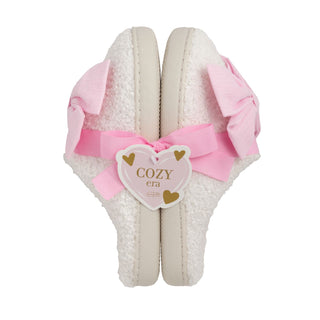 White slippers with pink bow and 'COZY era' label on a white background