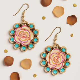 Gold dangle earrings featuring a cream rose center with pink glitter edges, surrounded by small turquoise stones.