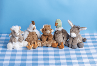 Five plush toys on a blue checkered tablecloth with a blue background