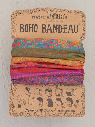 A Natural Life "Boho Bandeau" featuring a rich, autumnal patchwork of tiny ditsy floral patterns in deep red, orange, purple, and forest green. The multi-functional accessory is presented on its classic brown cardboard display.