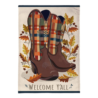 A rectangular decorative wall hanging or flag-style textile with a western theme, featuring a pair of brown cowboy boots with plaid interiors, surrounded by autumn leaves and the words “WELCOME Y’ALL” at the bottom.
