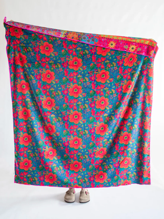 Colorful floral-patterned fabric draped over a surface with a white background