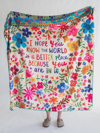 Colorful floral blanket with motivational quote on a white background