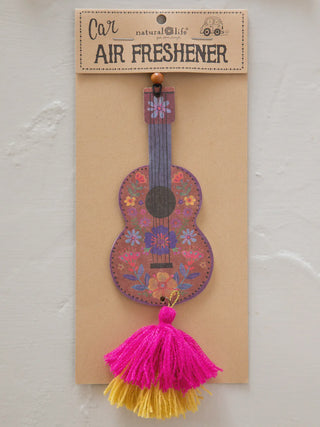 Decorative guitar-shaped air freshener with tassels on a beige card