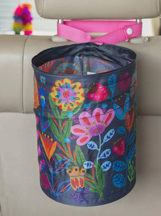 Colorful floral-patterned pop-up trash can on a car seat with a pink strap.