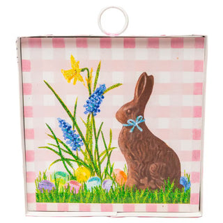 Chocolate bunny with flowers and eggs on a checkered background