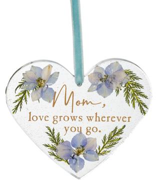 Heart-shaped decorative plaque with floral design and text 'Mom, love grows wherever you go.'