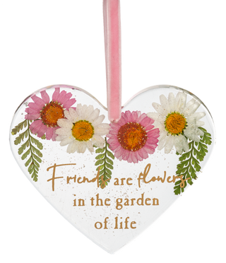 Heart-shaped ornament with flowers and text 'Friends are flowering in the garden of life' on a white background