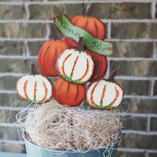 Decorative metal pumpkin display with a 'Pumpkins 50c' sign 