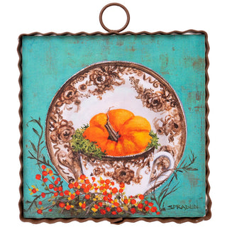 Decorative plate with a pumpkin design on a turquoise background