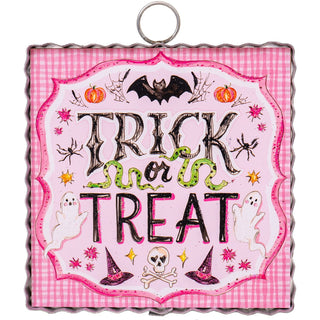 'Trick or Treat' text on a pink checkered Halloween-themed decorative charm with