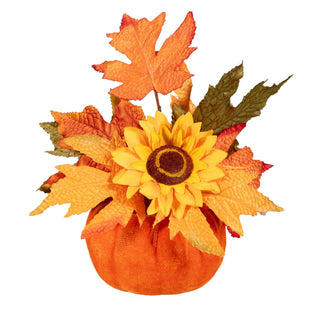 An autumn floral arrangement featuring a yellow sunflower with a dark brown center, surrounded by orange and yellow maple leaves and a small orange pumpkin base, isolated on a white background.
