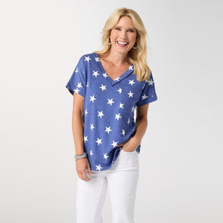 Woman wearing a blue shirt with white star patterns on a plain background